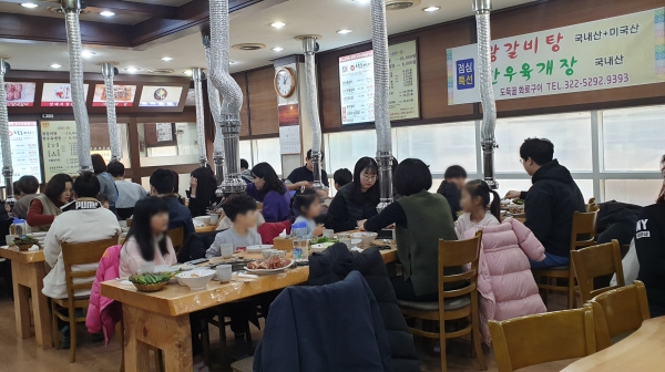 도둑골 화로구이 식당에서 지역아동센터 아이들과 선생님, 자원봉사자들이 식사하는 모습