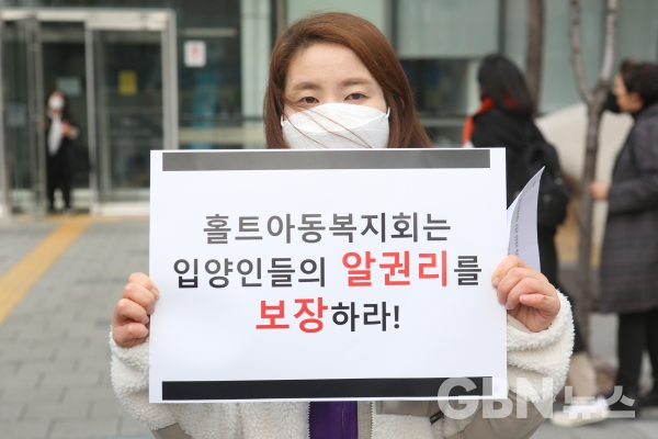아동단체들이 23일 오후 서울 마포구 홀트아동복지회 앞에서 진행한 기자회견에서 한 참석자가 피켓을 들고 있다. (사진=서한결 기자)