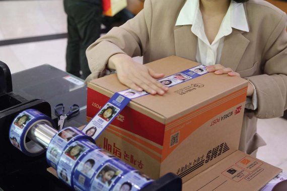 서울 강남 우체국에서 고객이 장기 실종아동 정보가 인쇄된 ‘호프테이프’를 이용해 택배 상자를 밀봉하고 있다. (사진=제일기획)